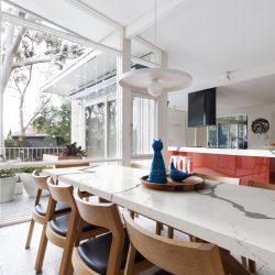 Scandinavian styled dining room and open plan kitchen with patio outlook