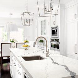 Bright horizontal image of classic white kitchen, with marble island.